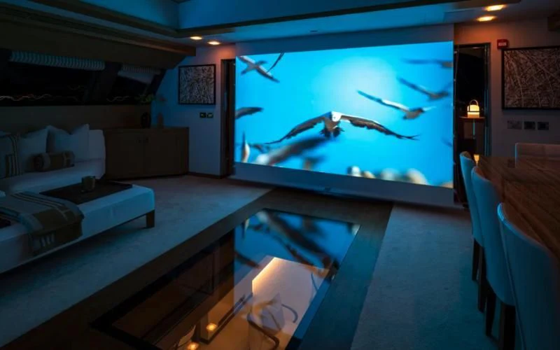 a room with a large screen aboard QHT Yacht for Sale