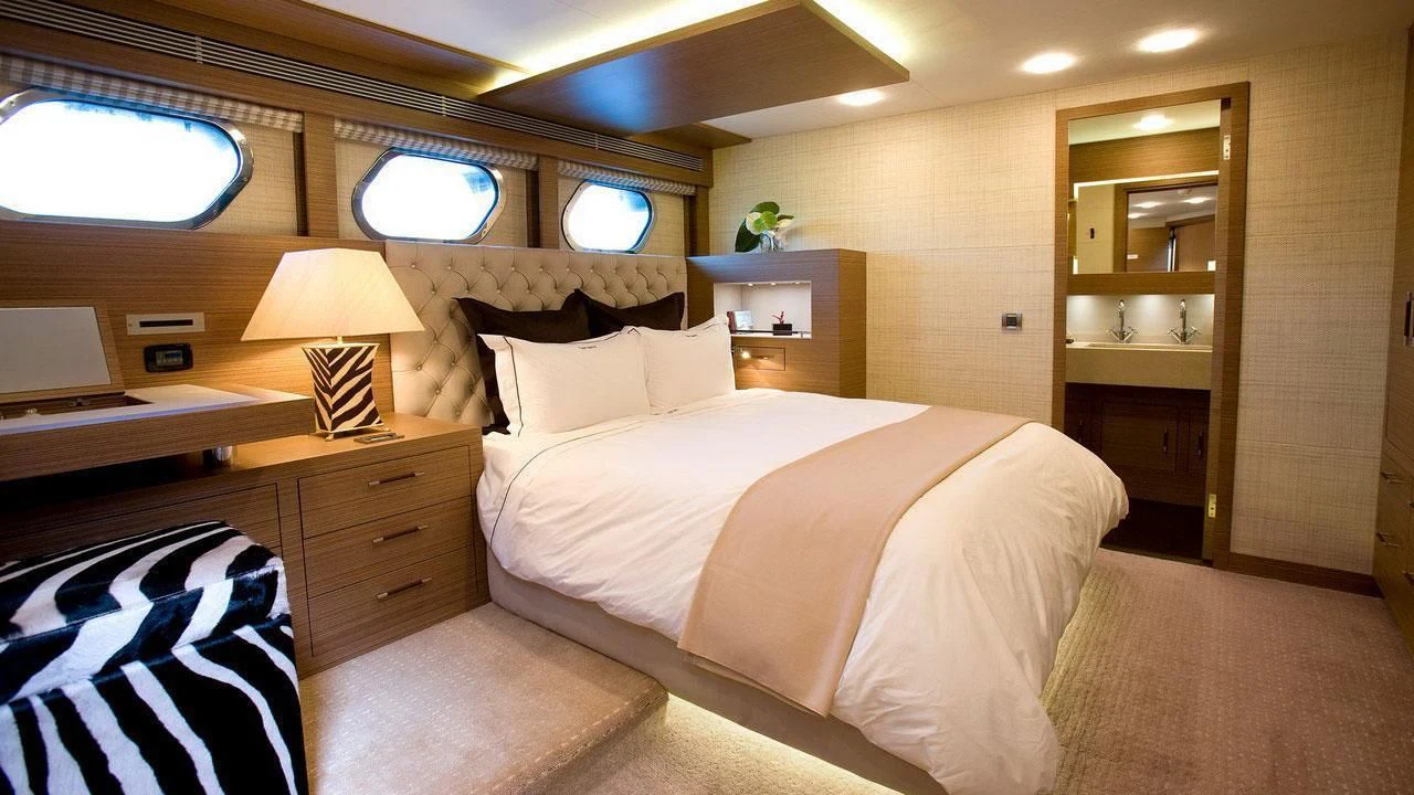 a bedroom with a bed and a desk aboard QHT Yacht for Sale
