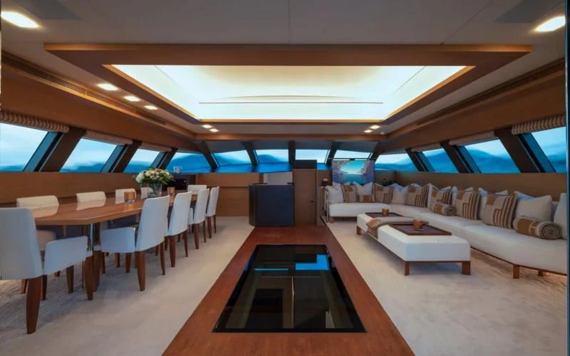 a room with tables and chairs aboard QHT Yacht for Sale