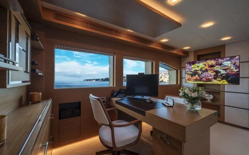 a room with a desk and a tv aboard QHT Yacht for Sale