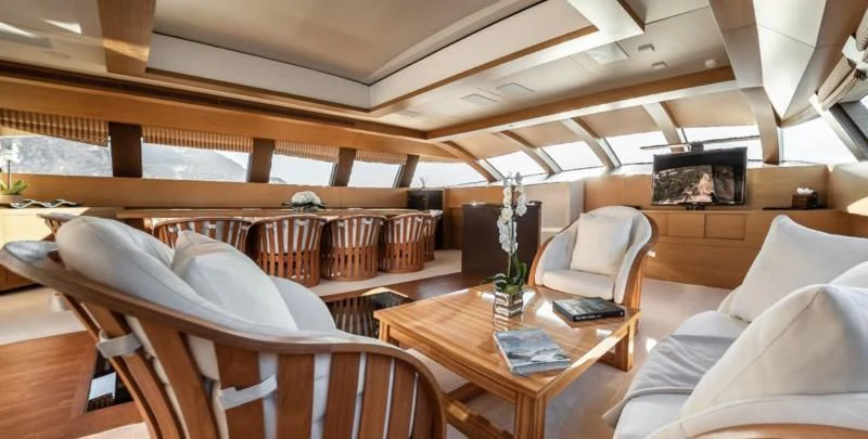 a room with a table and chairs aboard QHT Yacht for Sale