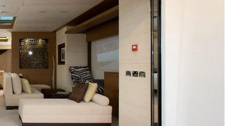 a room with a couch and a mirror aboard QHT Yacht for Sale