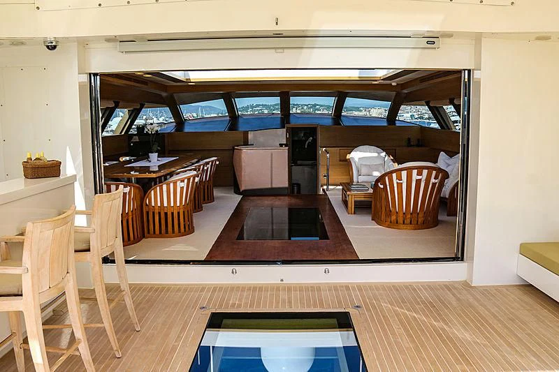a room with a table chairs and a tv aboard QHT Yacht for Sale