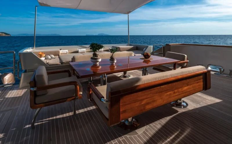 a table on a deck overlooking the ocean aboard QHT Yacht for Sale