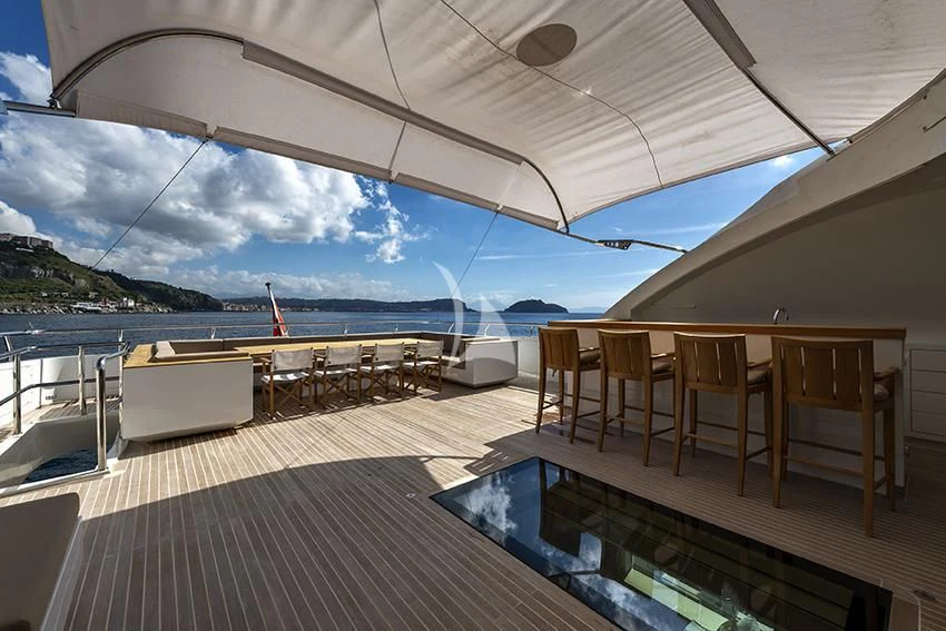 a deck with a large body of water and a large boat in the background aboard QHT Yacht for Sale