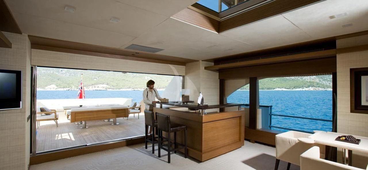 a person sitting at a desk in a room with a large window aboard QHT Yacht for Sale