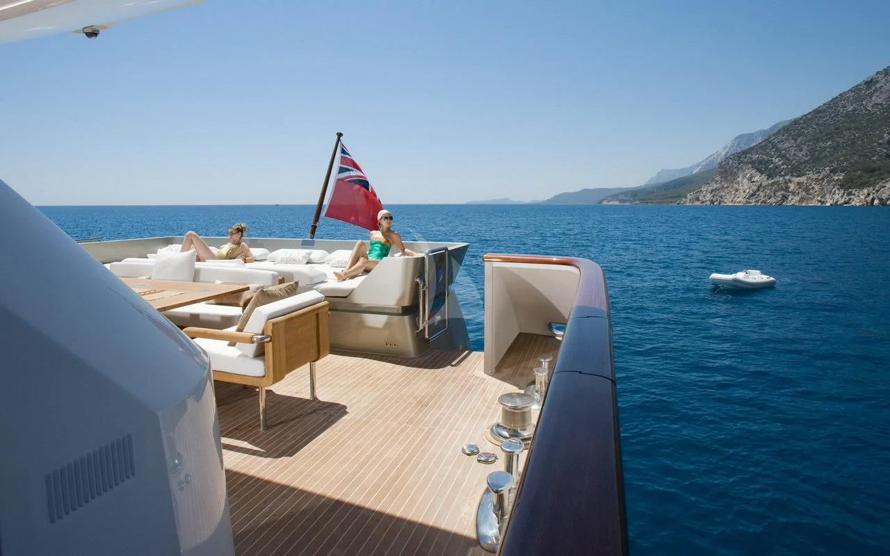 a boat with a flag on the front aboard QHT Yacht for Sale