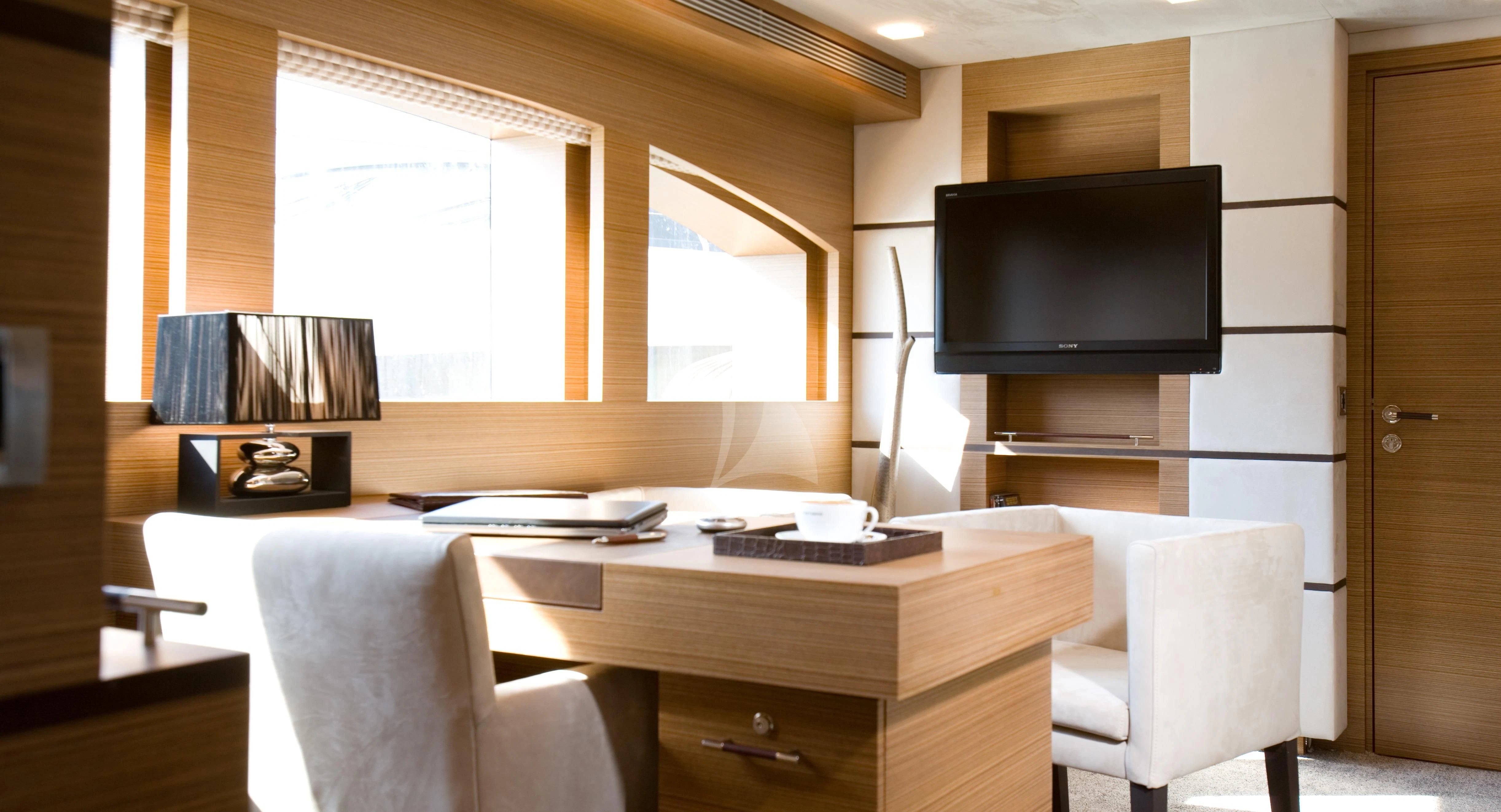 a room with a tv and a table aboard QHT Yacht for Sale