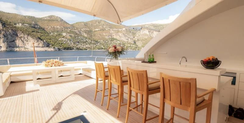 a table and chairs on a balcony aboard QHT Yacht for Sale