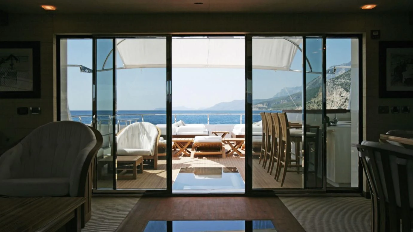 a room with a view of the ocean and a deck aboard QHT Yacht for Sale