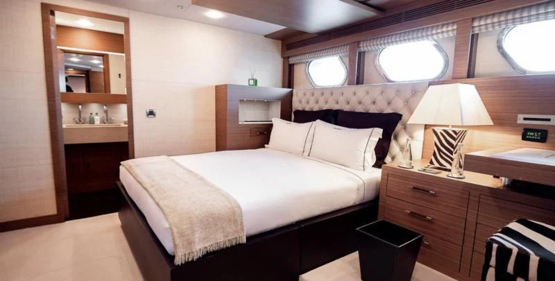 a bedroom with a bed and a desk aboard QHT Yacht for Sale