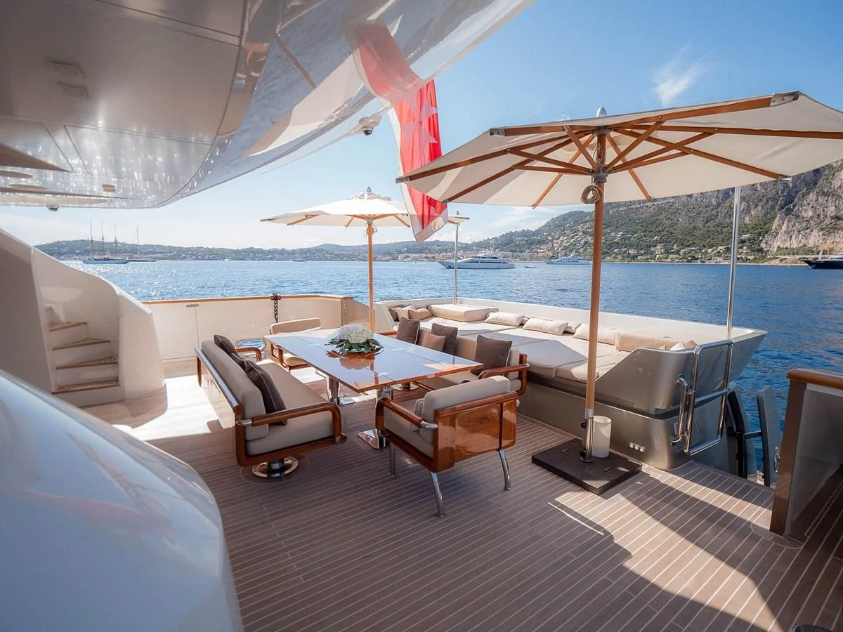 a table and chairs on a deck aboard QHT Yacht for Sale