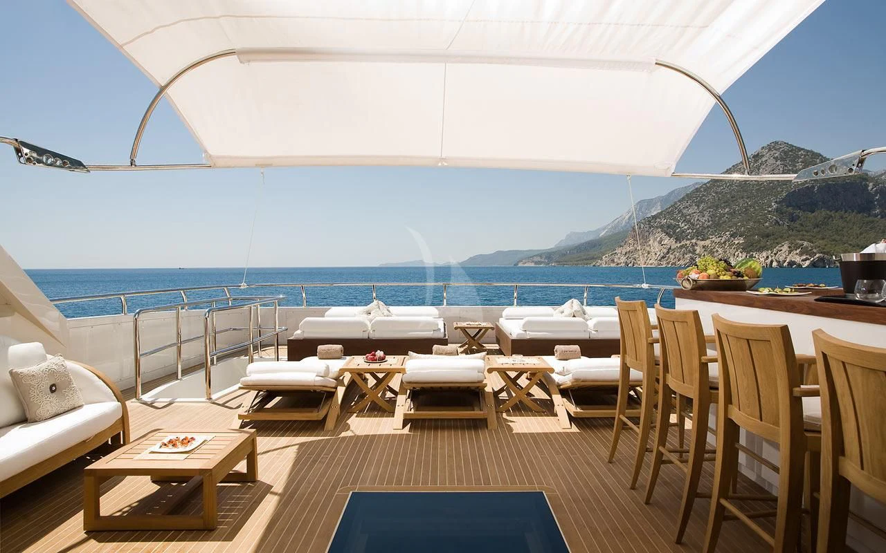 a room with tables and chairs aboard QHT Yacht for Sale