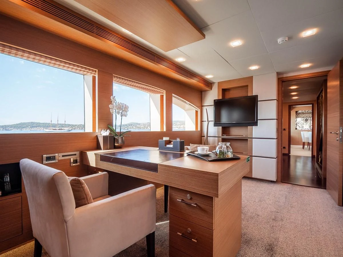 a living room with a tv and a desk aboard QHT Yacht for Sale