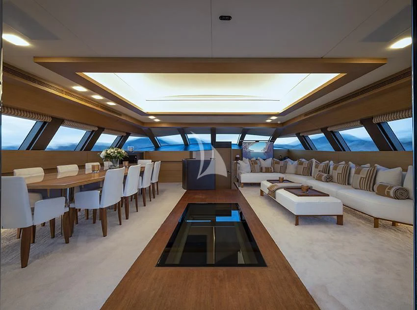 a room with tables and chairs aboard QHT Yacht for Sale