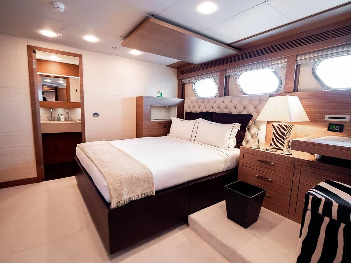 a bedroom with a bed and a desk aboard QHT Yacht for Sale
