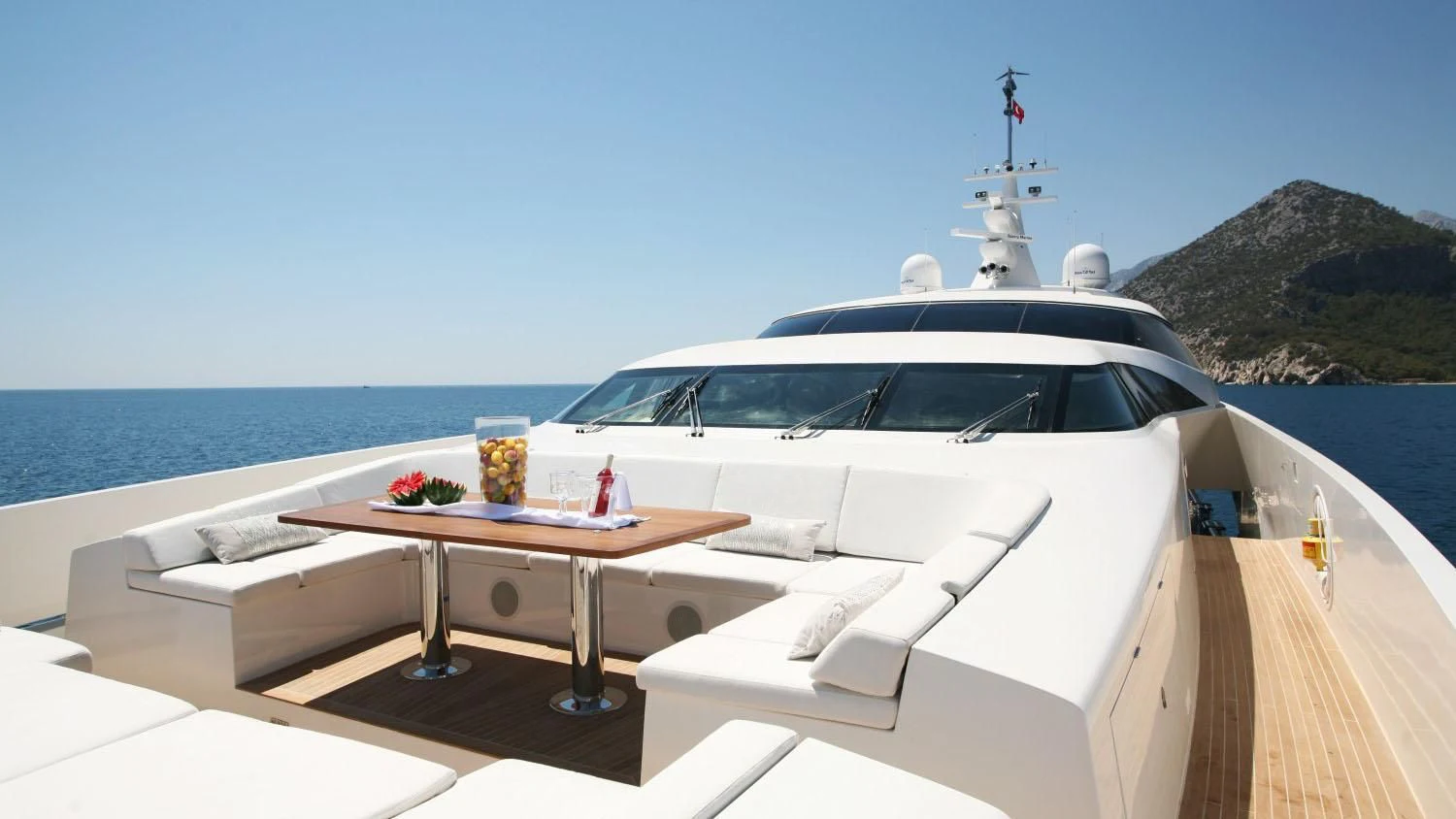 a white yacht on a beach aboard QHT Yacht for Sale