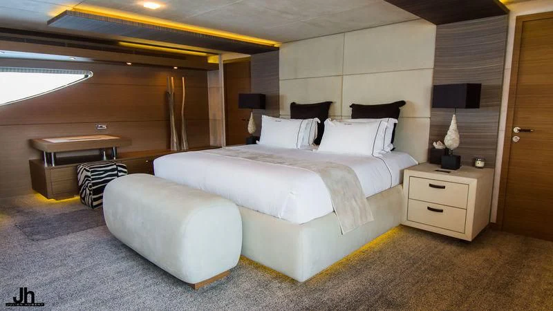 a room with a bed and a desk aboard QHT Yacht for Sale