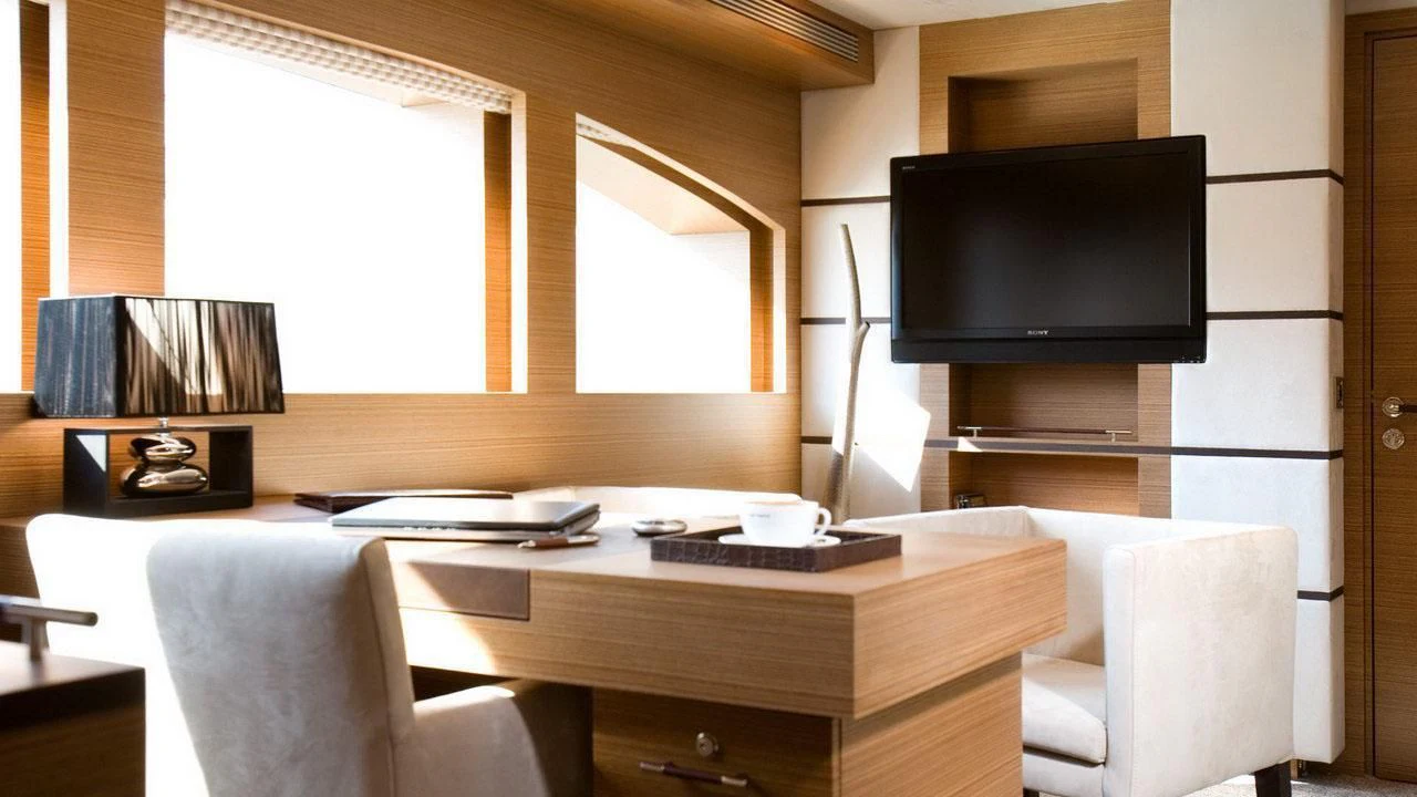 a room with a tv and a table aboard QHT Yacht for Sale