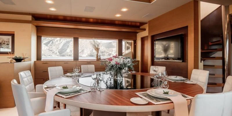 a dining room with a large screen aboard QHT Yacht for Sale