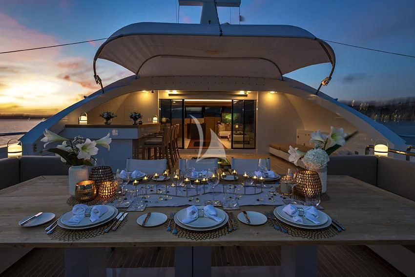 a table with plates and glasses aboard QHT Yacht for Sale