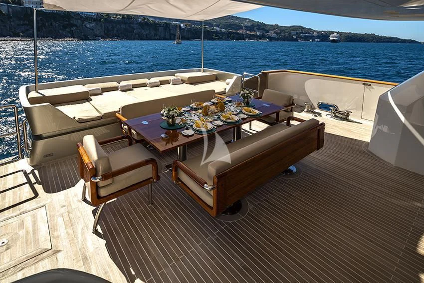a table on a deck overlooking the ocean aboard QHT Yacht for Sale