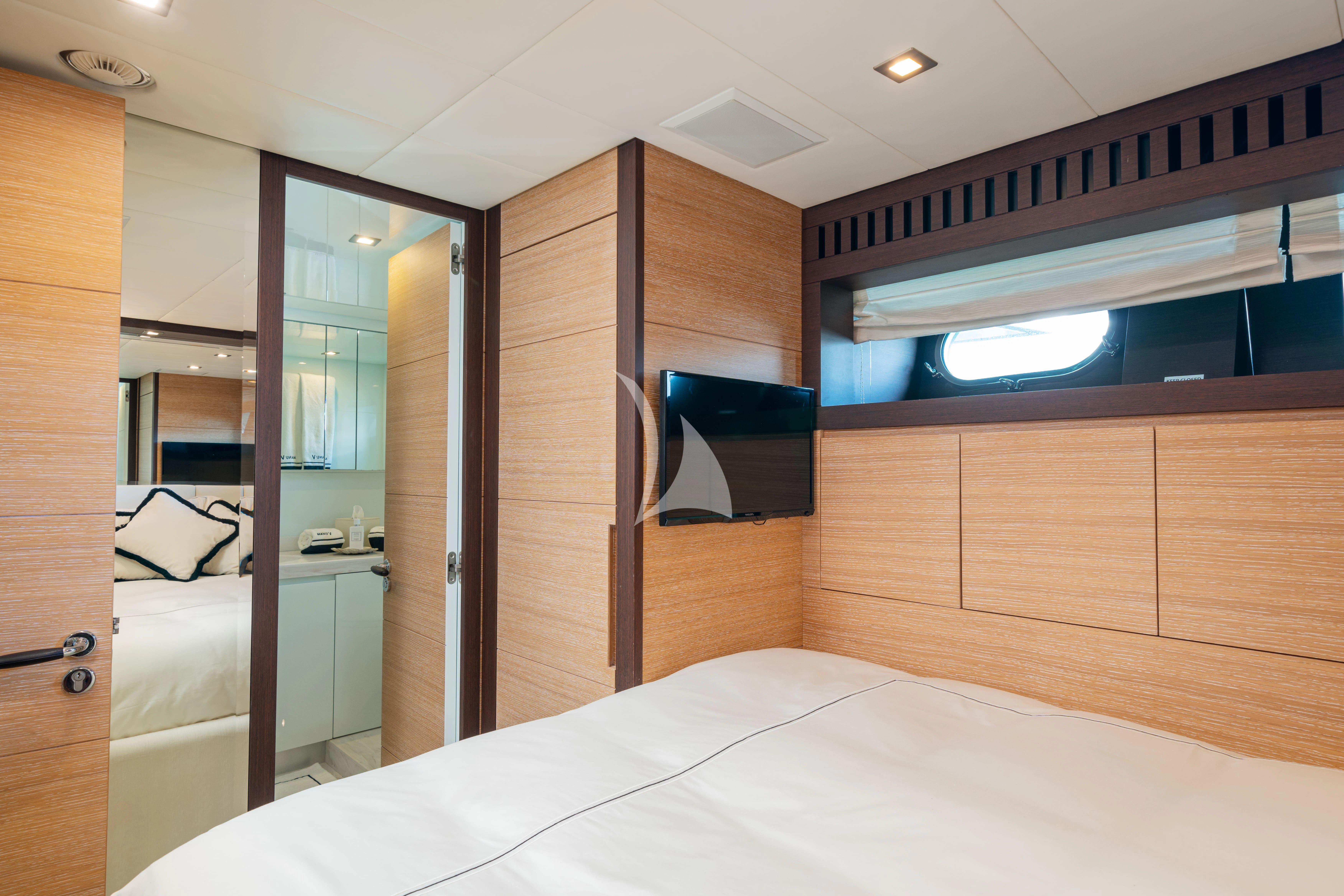 a room with a bed and a television aboard MANU V Yacht for Sale
