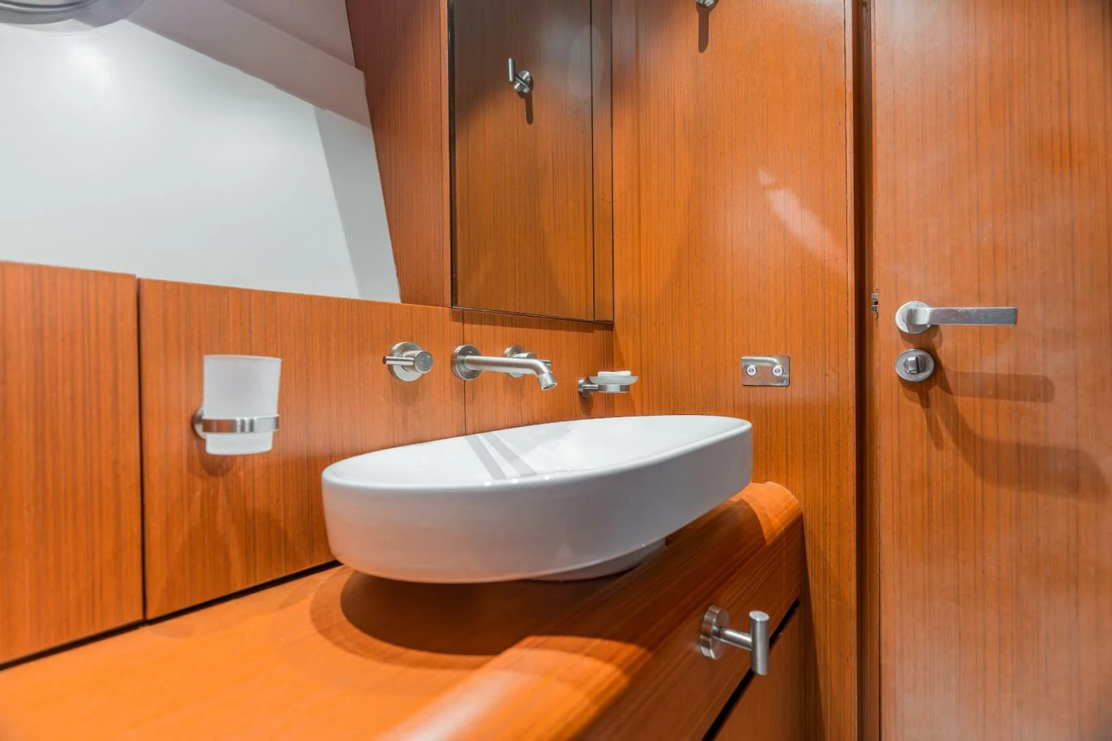 a bathroom with a sink and wooden cabinets aboard BLUWATER Yacht for Sale