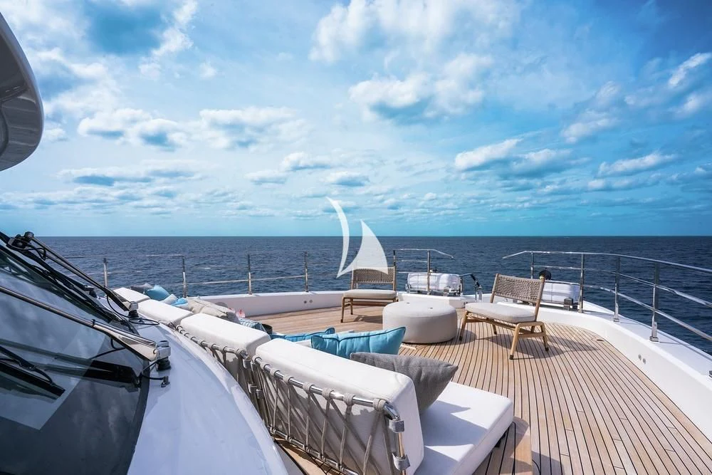 a deck with a view of the ocean and a large boat aboard JYC Yacht for Sale