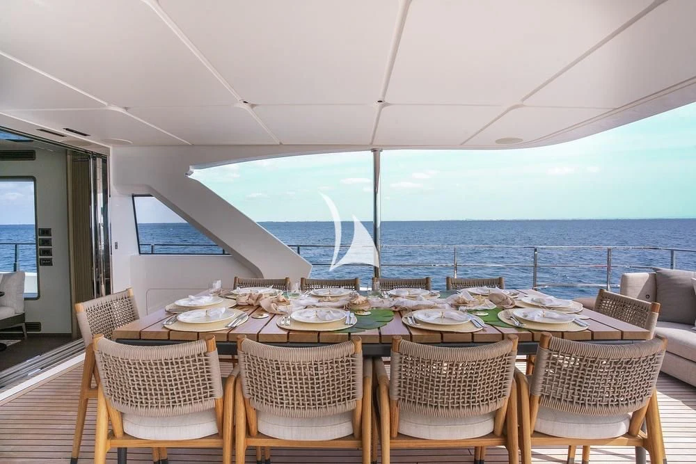 a table set for a meal on a deck aboard JYC Yacht for Sale