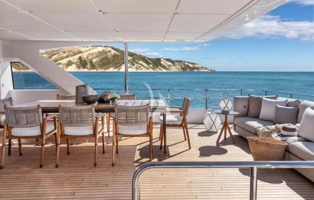 a deck with chairs and tables on it aboard JYC Yacht for Sale
