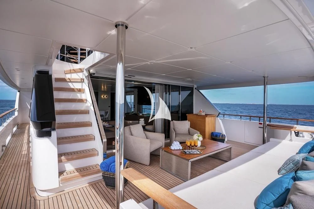 a boat with a deck and a table and a tv aboard JYC Yacht for Sale
