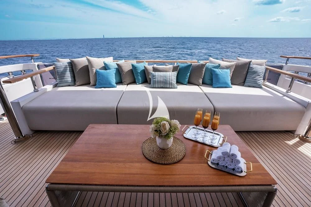 a couch with a table and a vase of flowers on it aboard JYC Yacht for Sale