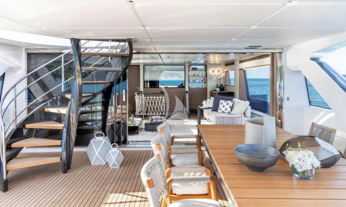 a room with a large bed and a table with chairs aboard JYC Yacht for Sale
