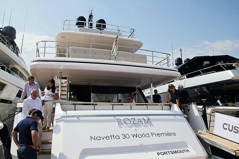 a group of people standing around a boat aboard JYC Yacht for Sale