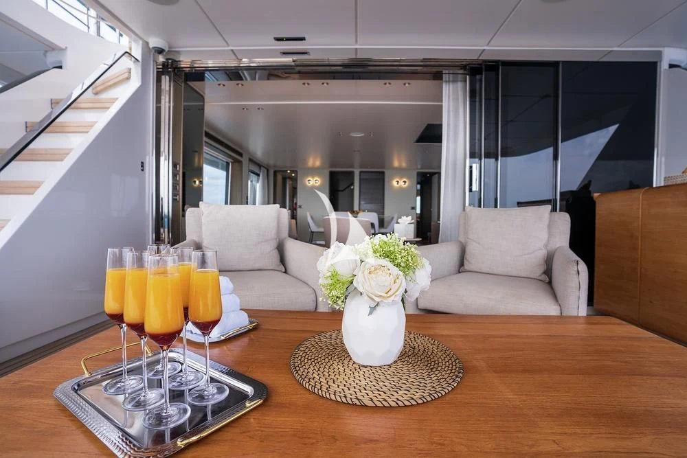 a table with glasses and a vase of flowers on it aboard JYC Yacht for Sale