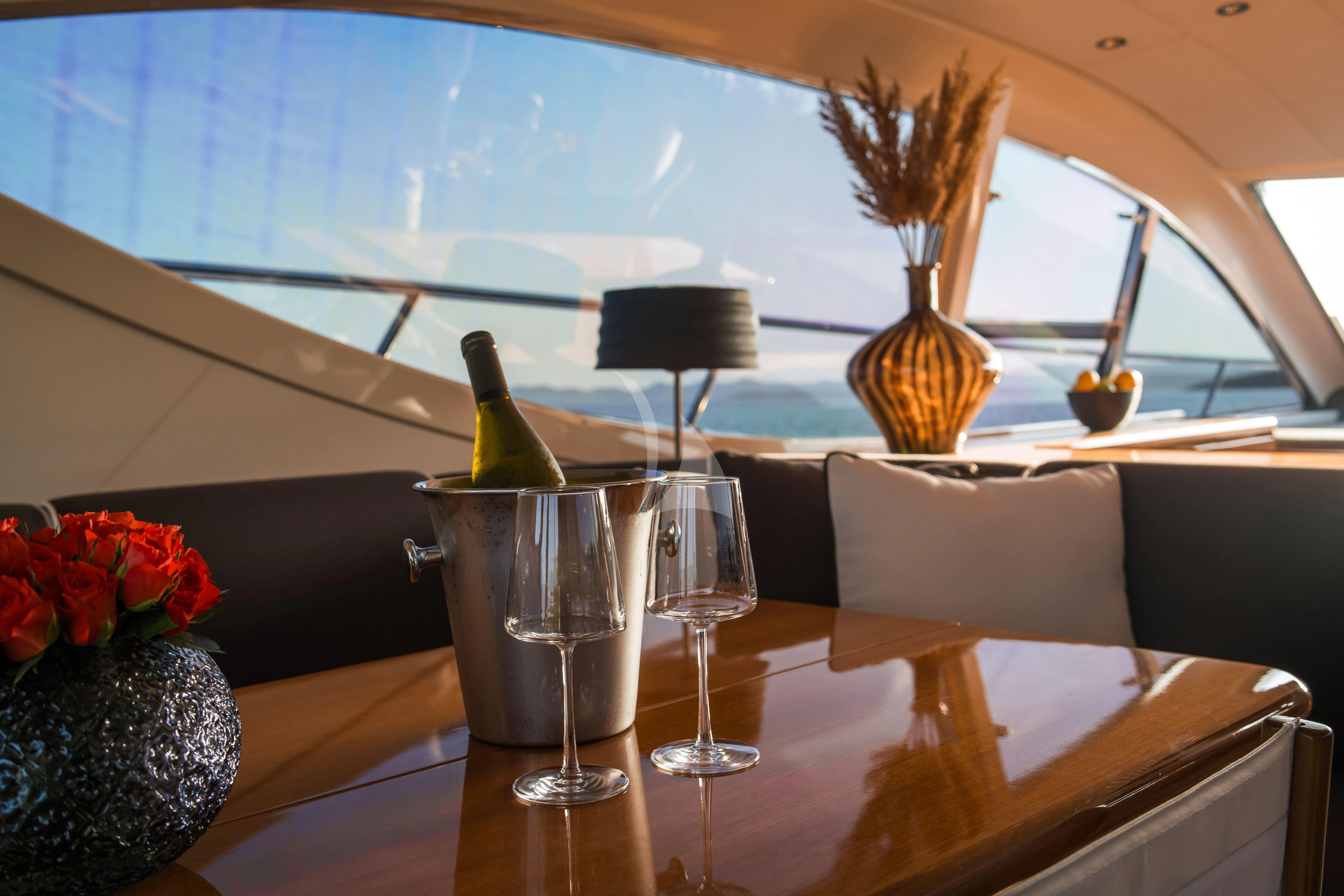 a bottle of wine and a glass on a table aboard TOBEKA Yacht for Sale