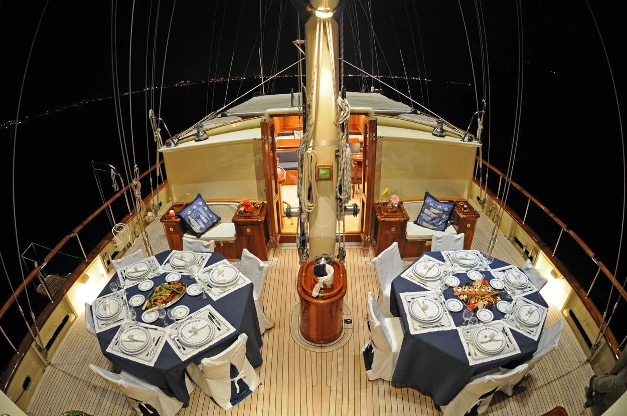 a room with a bed and a table with a chair aboard OFELIA Yacht for Sale