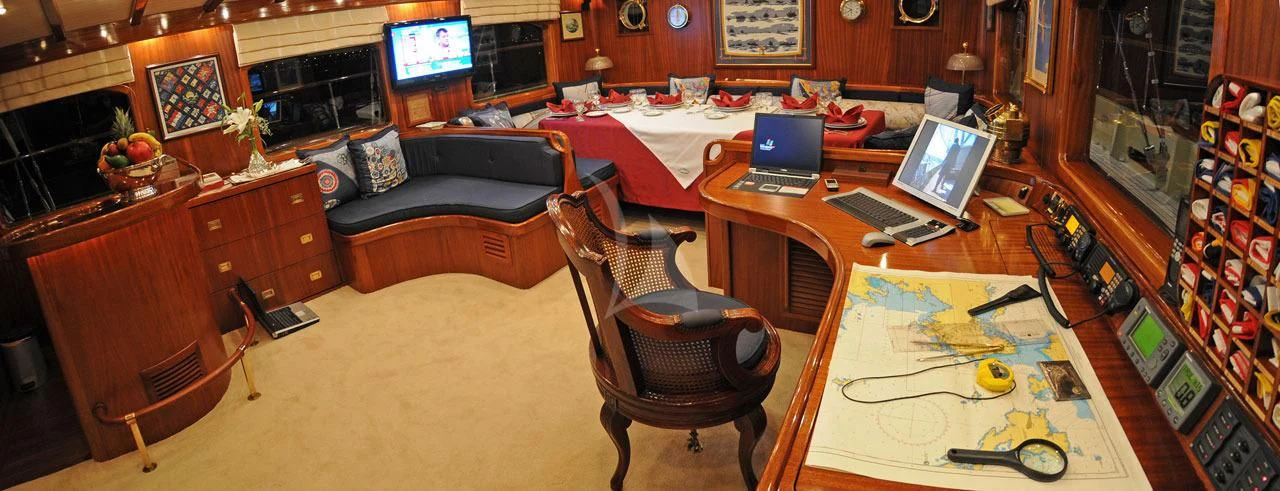 a living room with a laptop and a table aboard OFELIA Yacht for Sale