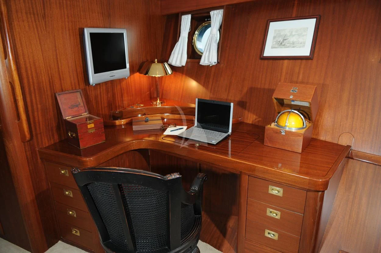 a laptop sits on a desk aboard OFELIA Yacht for Sale