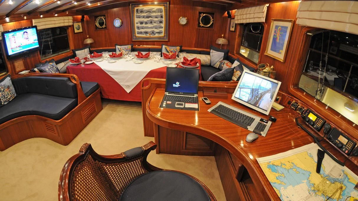 a room with a bed and a laptop on a desk aboard OFELIA Yacht for Sale