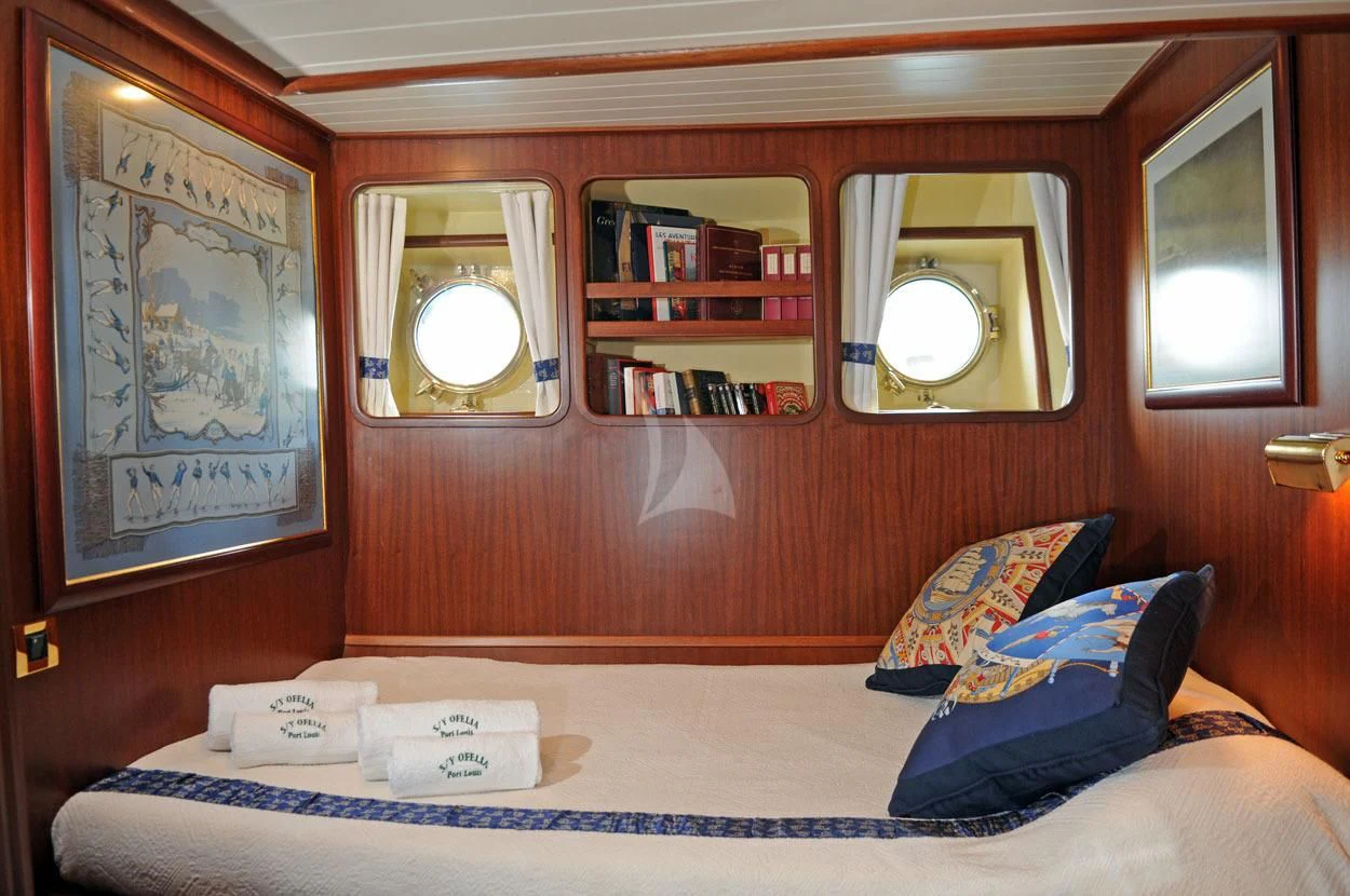 a bed with a blue pillow aboard OFELIA Yacht for Sale