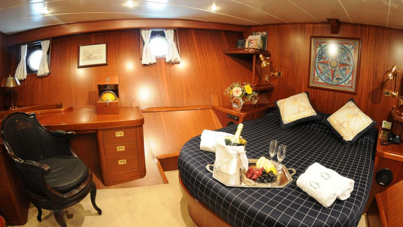 a bedroom with a bed and a desk aboard OFELIA Yacht for Sale