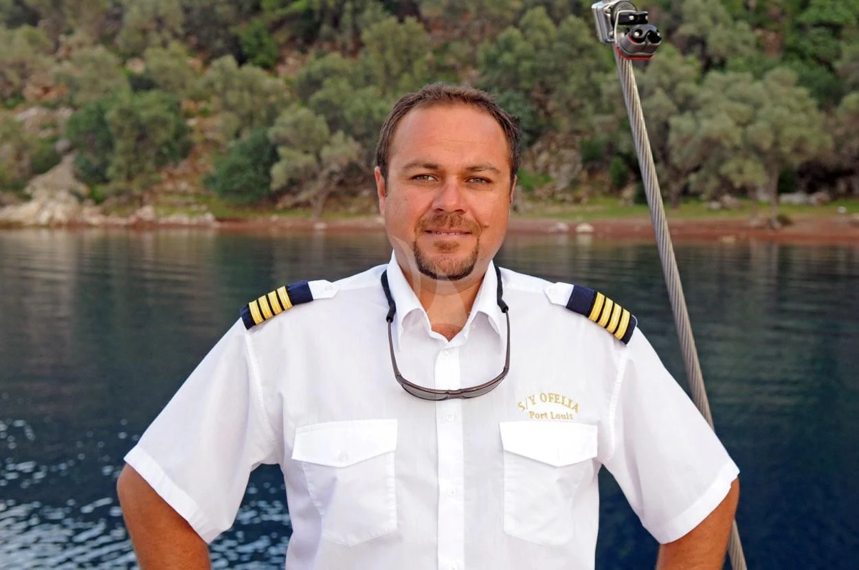 a man in a white uniform aboard OFELIA Yacht for Sale