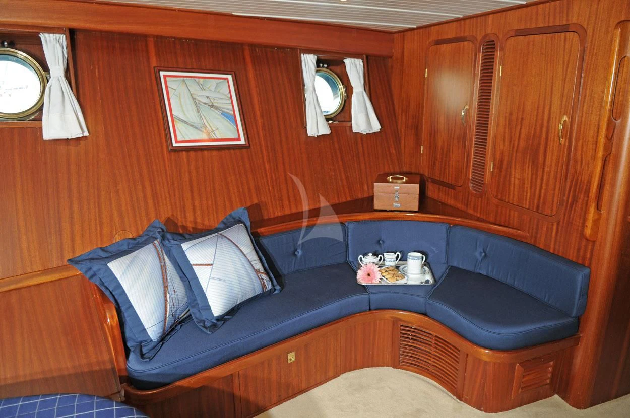 a blue couch in a room aboard OFELIA Yacht for Sale