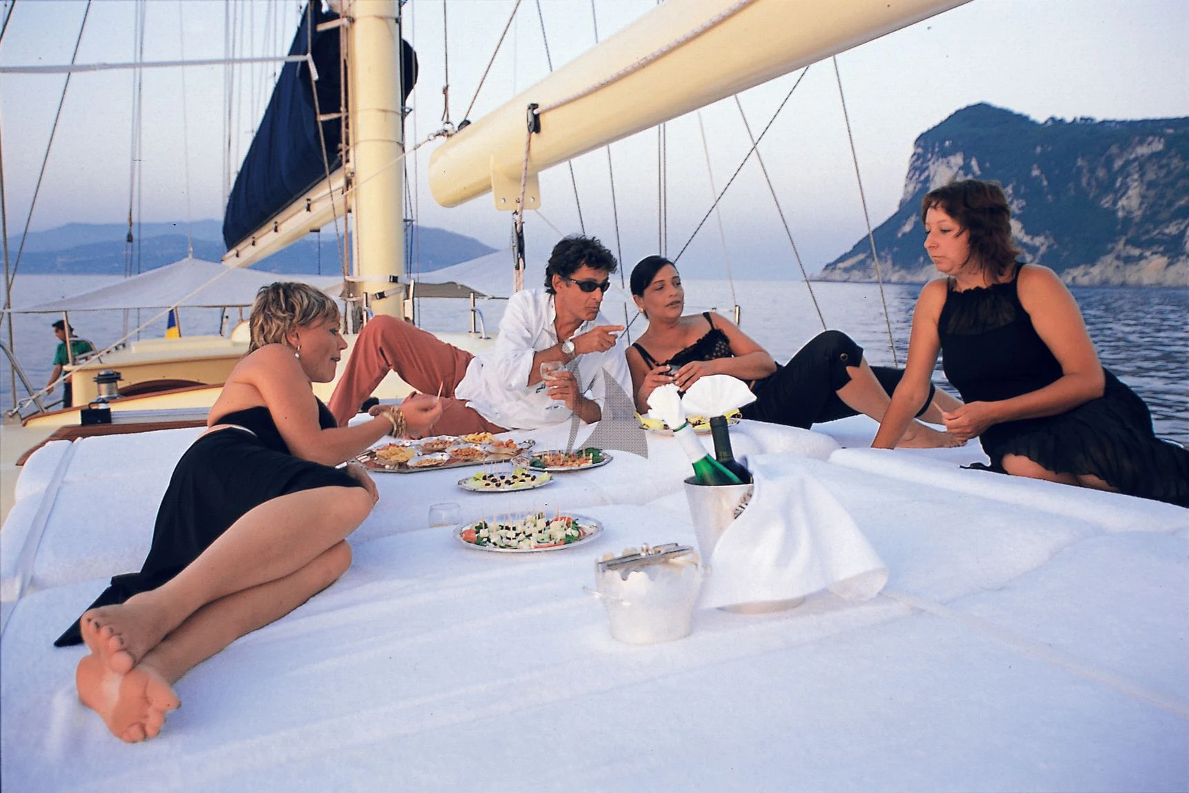 a group of people sitting on a boat eating food aboard OFELIA Yacht for Sale