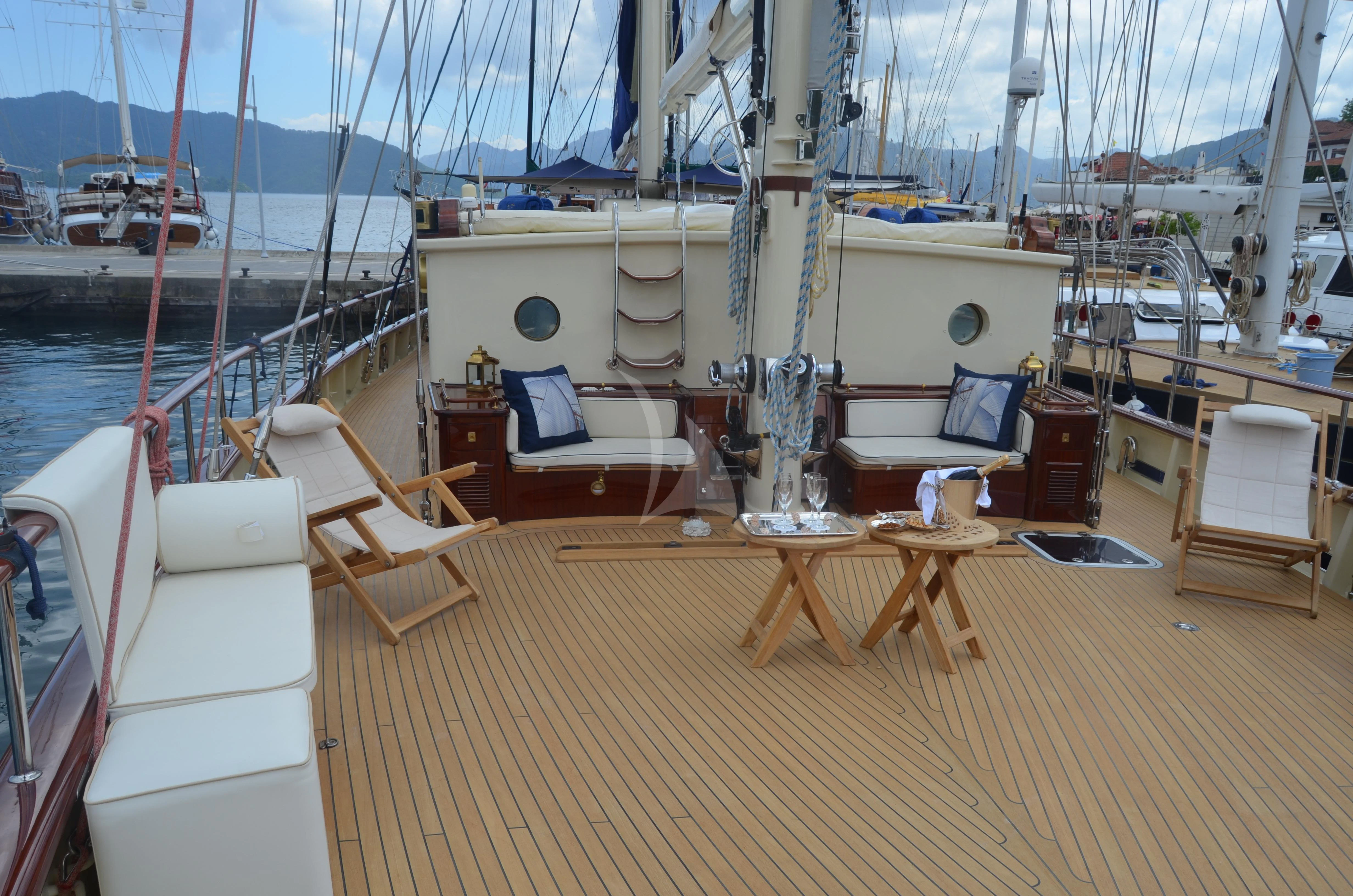 a deck with a table and chairs on it aboard OFELIA Yacht for Sale