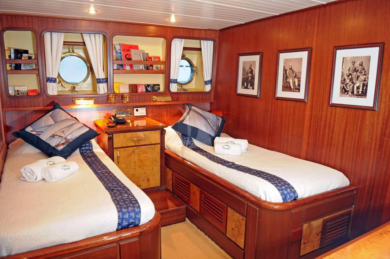 a bedroom with a bed and a mirror aboard OFELIA Yacht for Sale