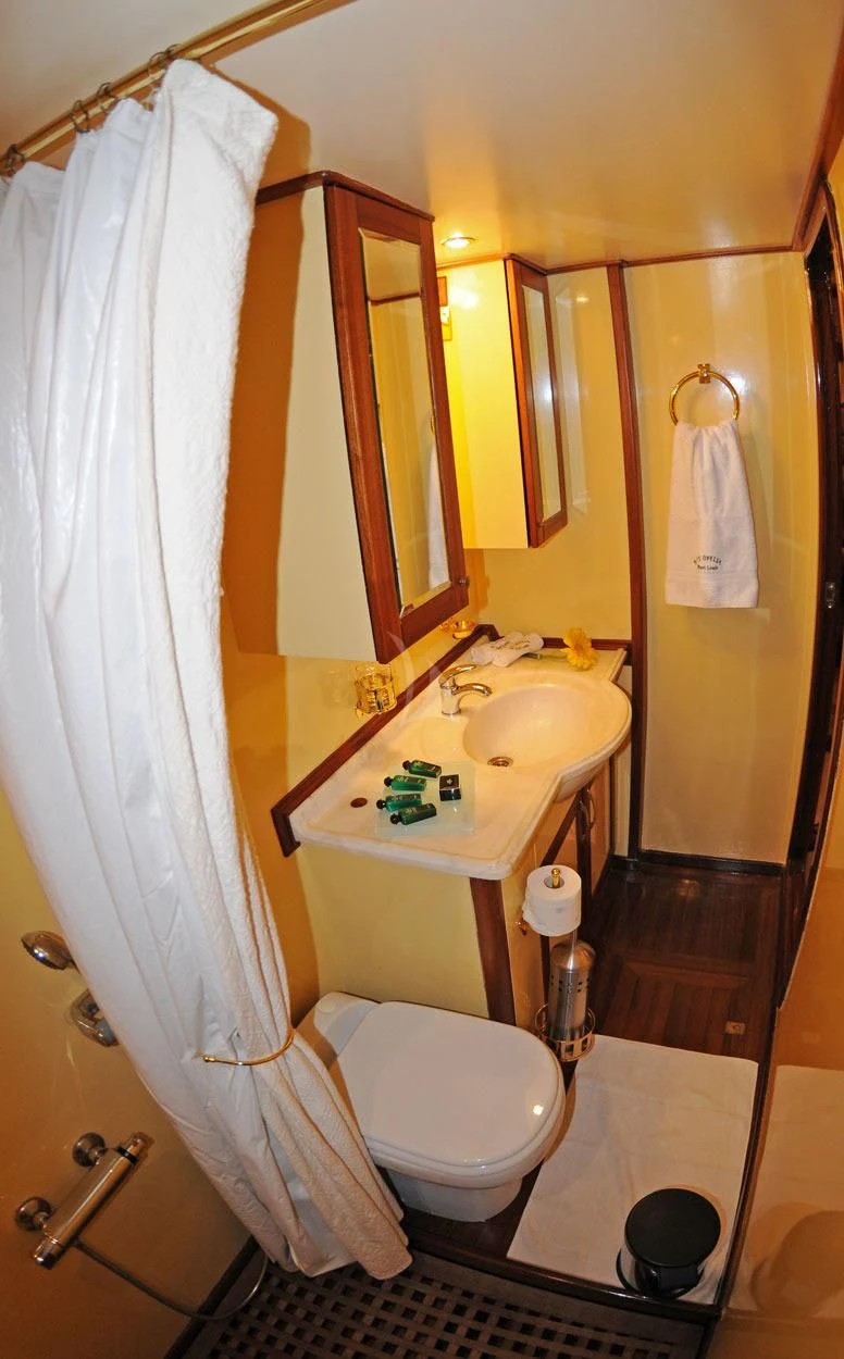 a bathroom with a sink toilet and a shower curtain aboard OFELIA Yacht for Sale