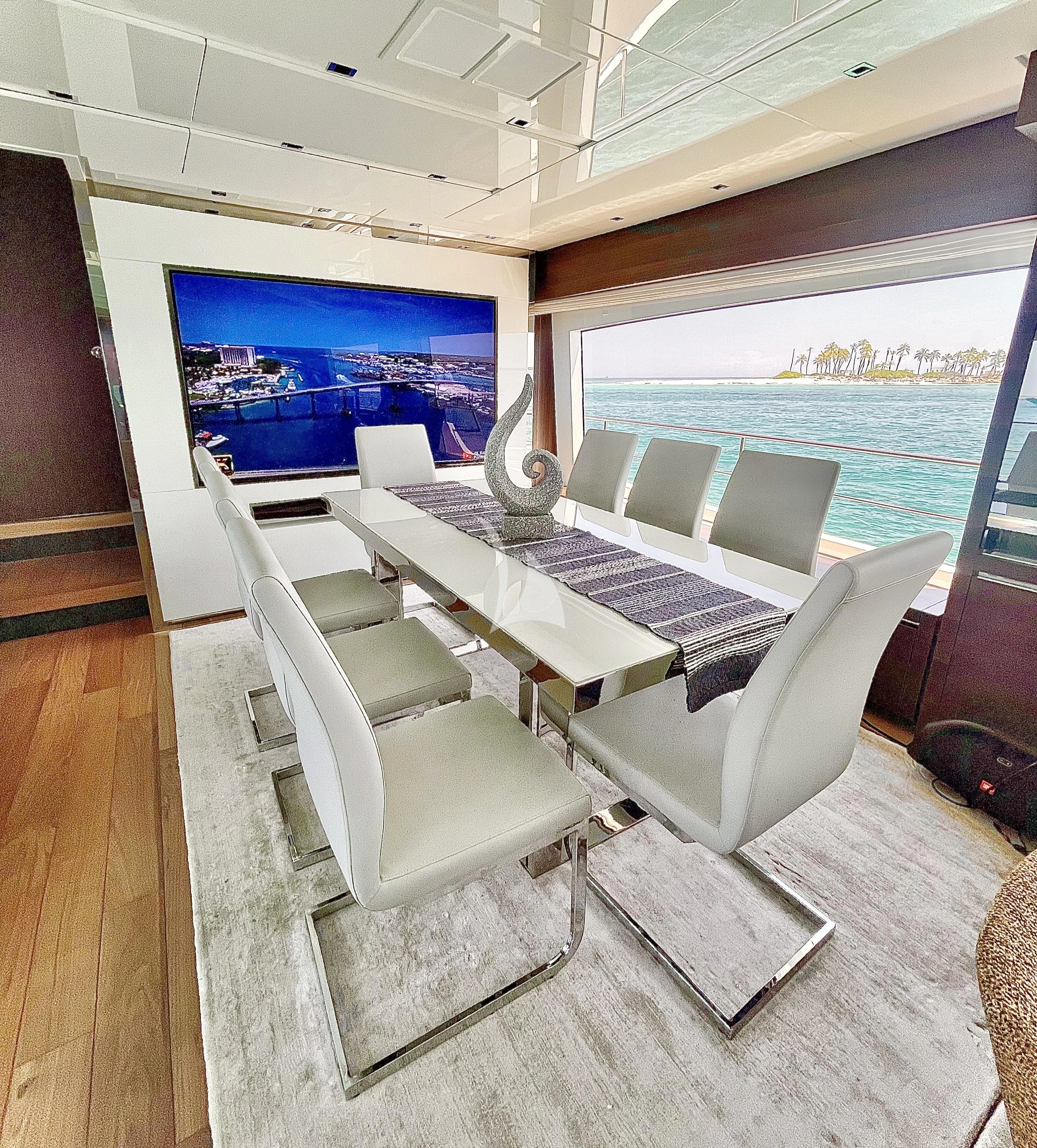 a room with a large window and a table with chairs and a laptop on it aboard C-DAZE Yacht for Sale